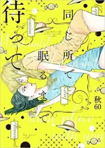 On a bright yellow background a blonde woman lays over a dark-haired woman, their faces close. They wear t-shirts and underwear and are pressed close, on a diagonal across the cover, their heads lower than their legs. Text an images around them make the cover very busy. The text reads in black in Japanese 同じ所で眠るまで待って, in white in English, Wait Until I Sleep In the Same Place With You and small black letters onajitokorode nemurumadematte. Also in black characters on the cover is the creator's name, Aki60.