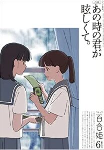 Two girls in white Japanese school uniforms, with blue collars and skirts stand in front of a window as they discuss something. One has a satisfied smile, as the other looks at her. The text reads "At that moment, you were dazzling."