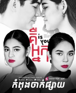 Promotional poster for the Cambodian yuri series Is You. At the top of the poster are Kun (left) and Sour (right), nuzzling nose to nose. At the bottom of the poster are Sour (left) and Neang (right); both have pulled-back hair and bright red lipstick, and are staring at the camera, not smiling.