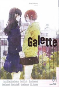 Magazine cover of two girls in different Japanese school uniforms holding hands in front of a fence behind which greenery and a building. One girl with short reddish-brown hair wears a short brown skirt and yellow windbreaker, her eyes open, but veiled. The other girl, with long dark hair in a longer blue skirt and dark blue jacket has her eyes closed.