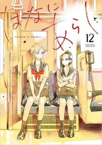 Book cover for Hana Ni Arashi, Volume12. Bathed in golden light, two high school girls wearing Japanese school uniforms of white blouses with blue sailor-style collars and blue skirts sit together on a commuter train, one smiles, one looks pensive.