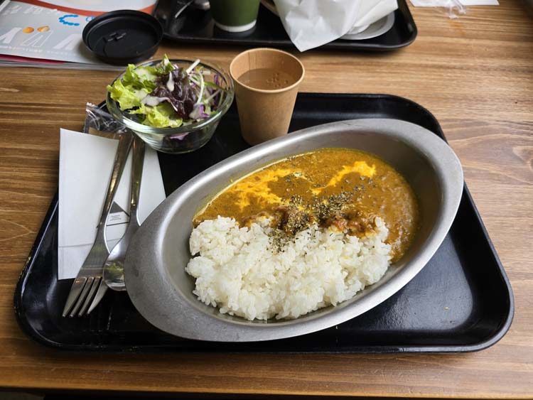 Curry and rice platter, with salad and a cup of water, napkin and flatware. Yuriten Osaka 20253, B. Baker.