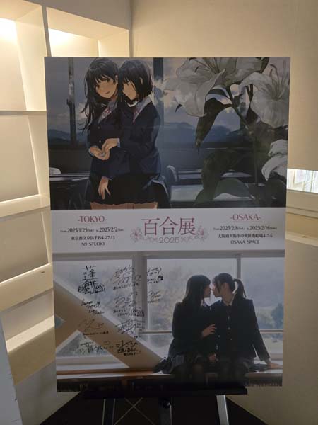 Signboard for the Yuriten event, with the same scene rendered as a live photo and an illustration. Two girls in dark school uniforms sit in a window holding hands intimately. Osaka Yuriten 2025, by B. Baker