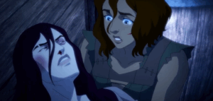 A woman with shoulder-length messy hair looks down at a woman with pale skin, and facial bruises with concern.