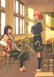 Two girls in a classroom. One, in a dark school uniform, the other wearing a satin jacket over hers. Neither speaks, the air hangs heavy between them.