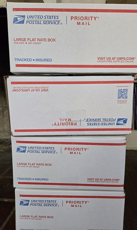 4 large usps flate rate boxes stacked.