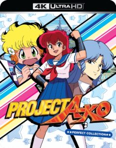 The cover for Project A-ko, which depicts a child-like blond girl, a girl with long red hair with her fist raised in the foreground, and a proper-looking blue-haired girl
