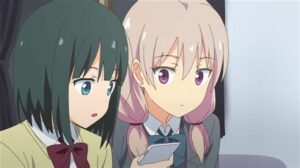 Two young women wearing different Japanese school uniforms, look into a cell phone