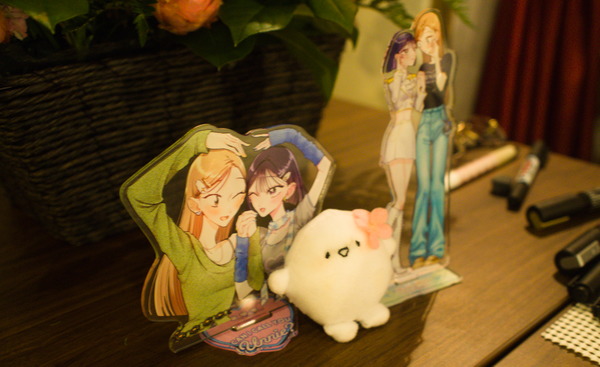 Acrylic standees of the main characters of Hanakage-sensei's book and a small plush "mascot" round, white character with small arms and legs, and a sakura blossom on it's "head."