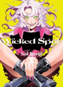 On a vivid yellow background, a woman with wild pink hair in hot pink and black, sits cross-legged, manicured long nails visible on her hand, smiling broadly with fangs showing and an intense look in her green eyes as looks a us.
