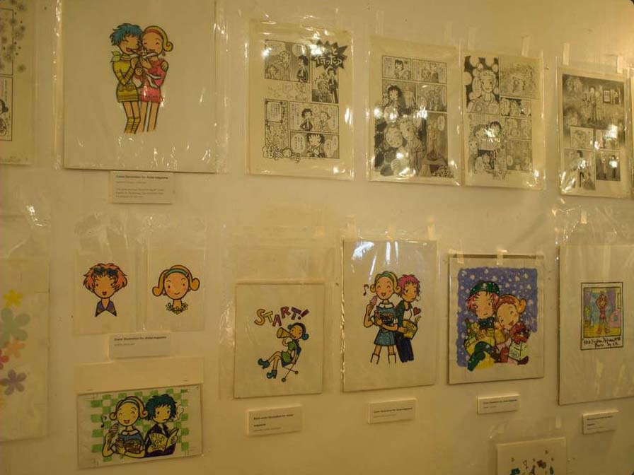 Original art by Ric Takashima displyed on the wall.. Color images of Rica and Miho, as well as original pages of Rica 'tte Kanji!?